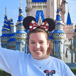 Headshot of Heather Pichardo, a Travel Agent at Favorite Grampy Travels, standing in front of Cinderella Castle at the Magic Kingdom at Walt Disney World