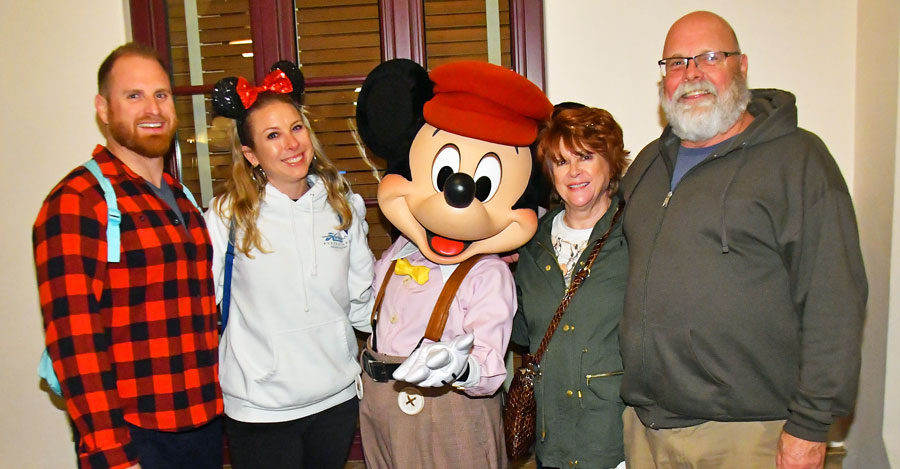 Jenny Meidling with her family at Walt Disney World posing with Mickey Mouse. She is a Travel Agent at Favorite Grampy Travels.