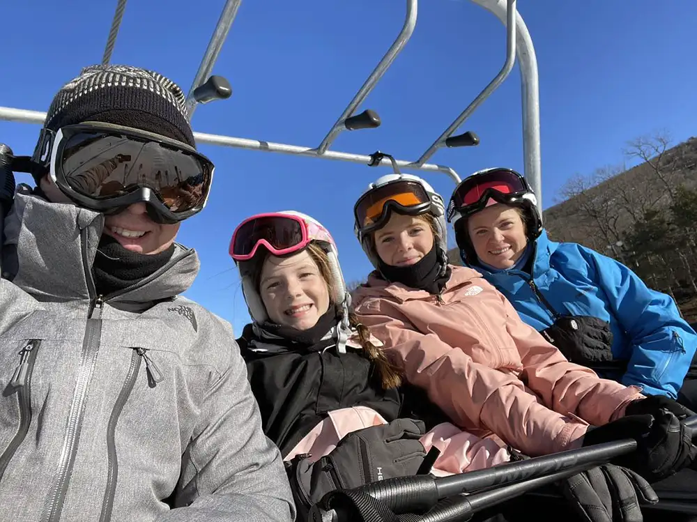 Laura Sellers Donovan with her family riding a skylift up a snow covered slop in Utah. 