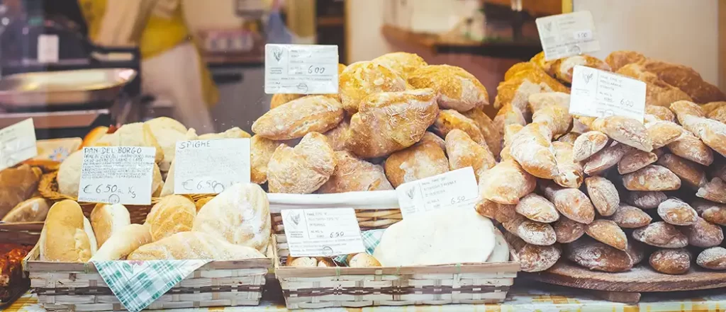 Bakery in Europe with a selection of fresh breads in baskets for sale.