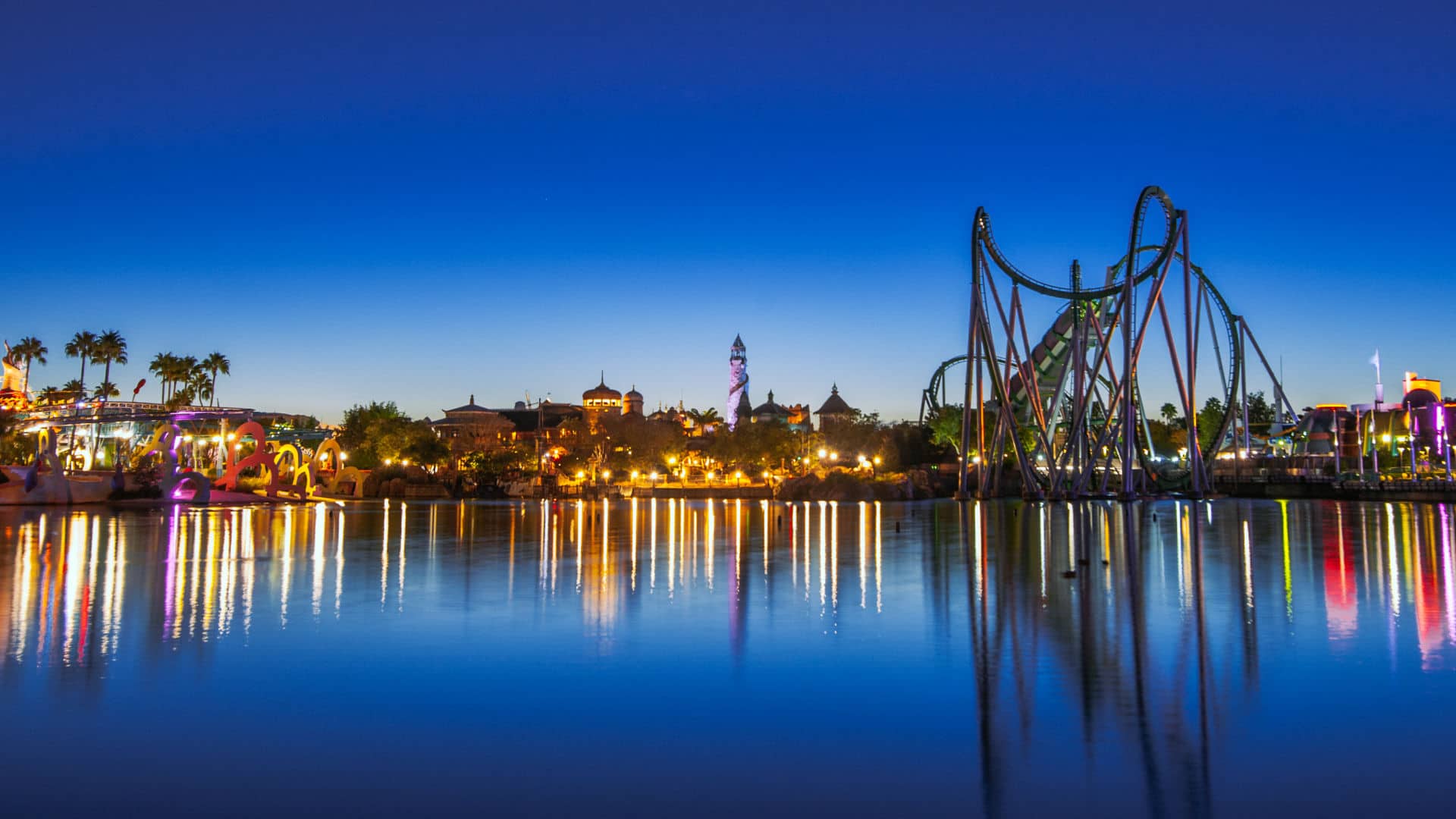 Universal Islands of Adventure lit up at night across the lagoon
