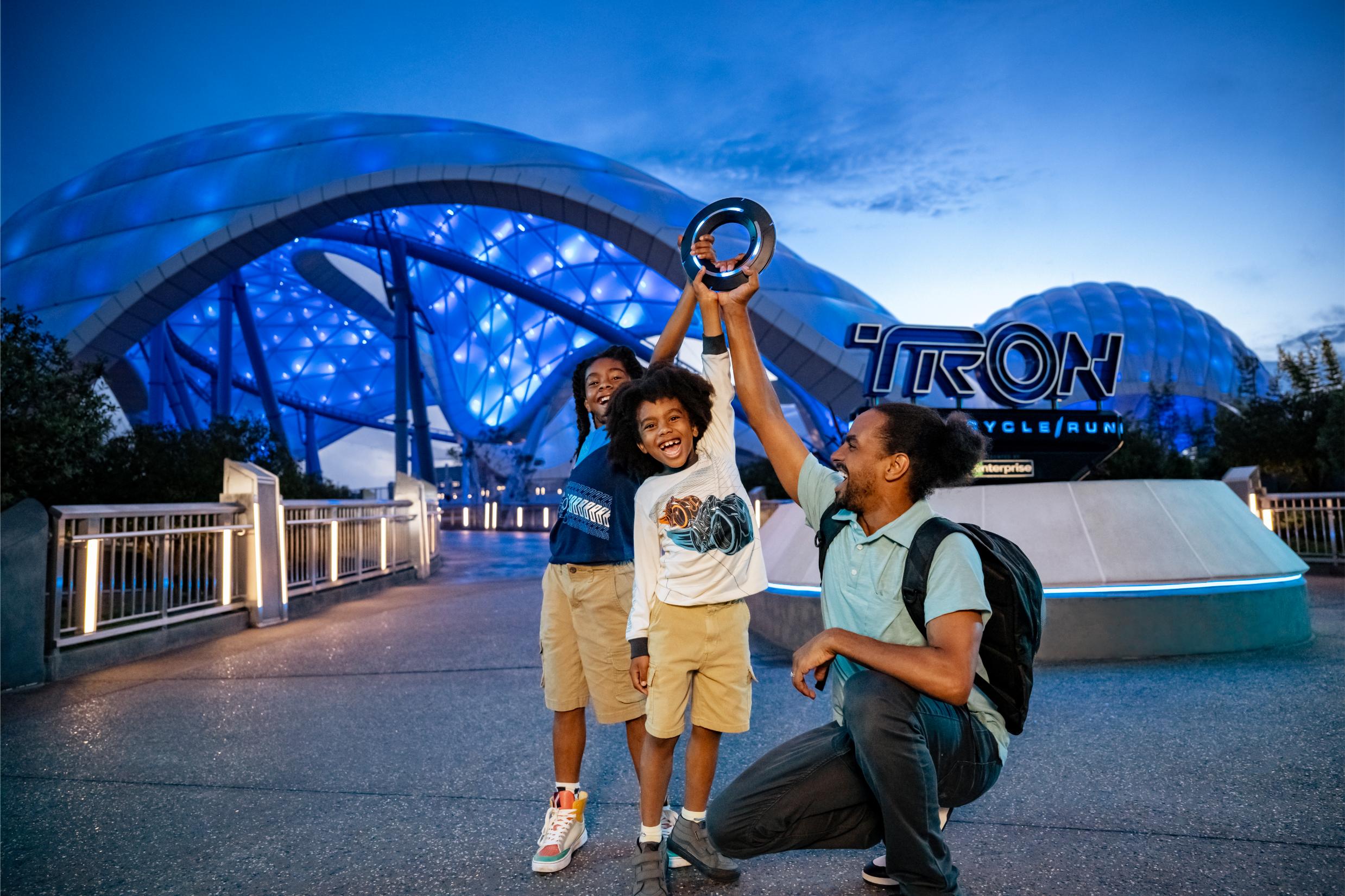Dad and two sons celebrating outside TRON Lightcycle Run at Magic Kingdom