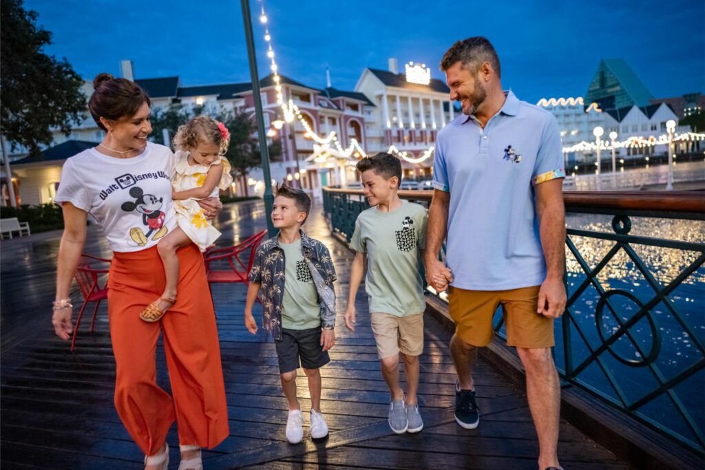 Family walking along the Disney BoardWalk waterfront at dusk