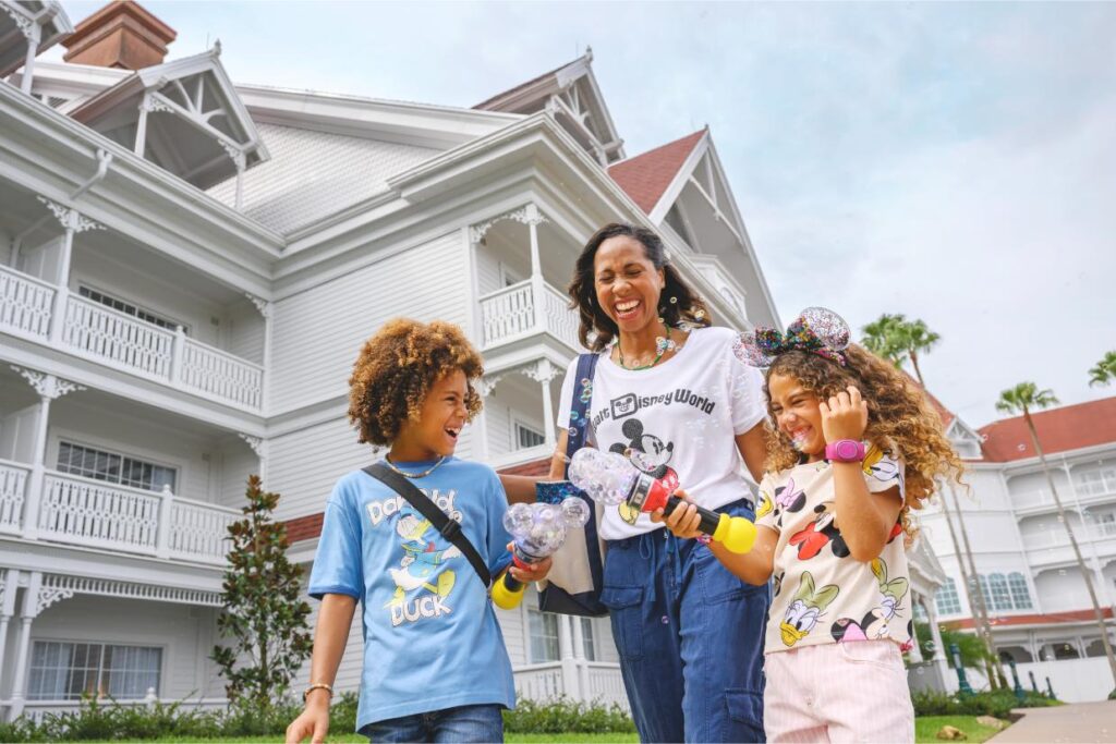 Mom and two kids with Mickey bubble wands on the lawn at Disney Grand Floridian Resort and Spa