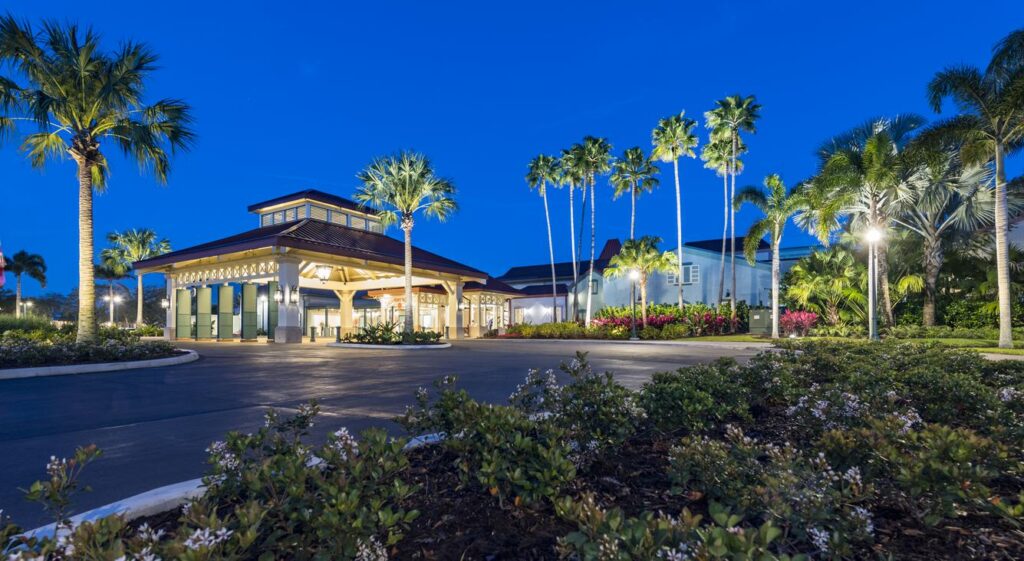 Entrance of Disney Caribbean Beach Resort lit up at dusk