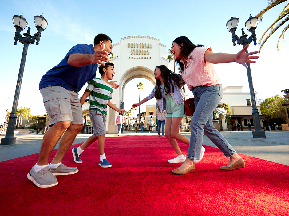 Universal Studios Entrence a - Favorite Grampy Travels a Family of Four Excitedly Greets Each Other on a Red Carpet at the Universal Studios Hollywood Entrance, Smiling Under a Sunny Sky—making Their Buy a Day Get a 2nd Day Free Ticket Worth It. - Favorite Grampy Travels