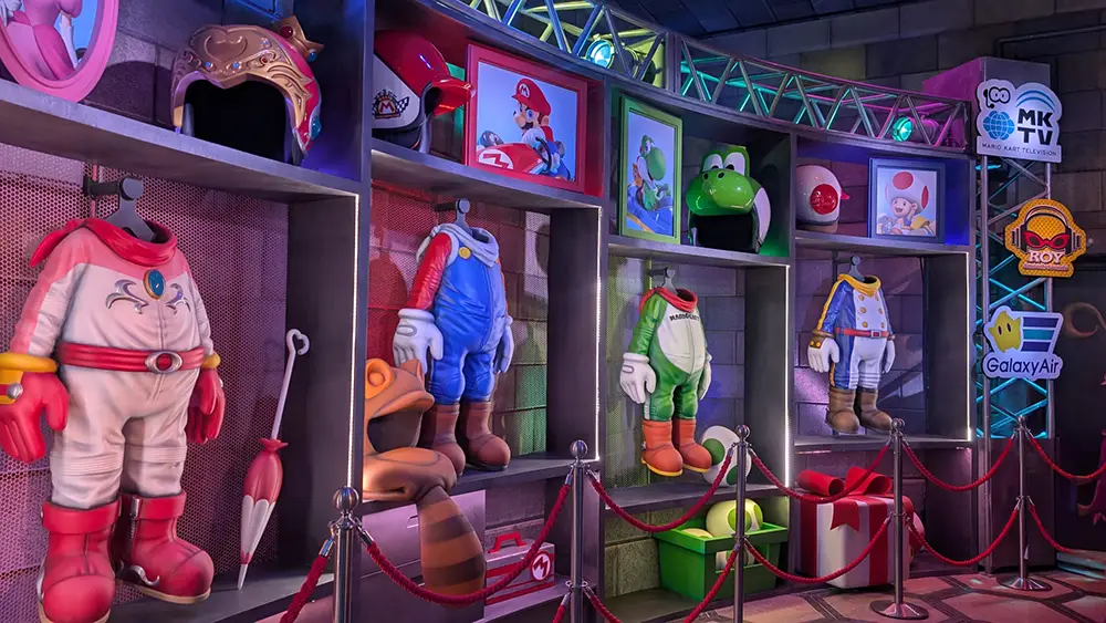 Colorful Display of Headless Costumes from the Mario Series, Including Mario and Luigi, Hang on Shelves with Themed Props and Character Portraits Under Bright Lighting, Evoking the Vibrant Energy of Super Nintendo World’s Epic Universe Exhibition Space. - Favorite Grampy Travels