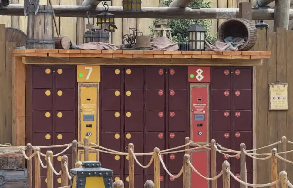 a Set of Maroon and Orange Lockers Numbered 7 and 8 Stands Against a Wooden Wall with Barrels, Lanterns, and Ropes in Front, Creating a Rustic, Theme-park Atmosphere Reminiscent of Universal Orlando Resort. - Favorite Grampy Travels - Favorite Grampy Travels 2026