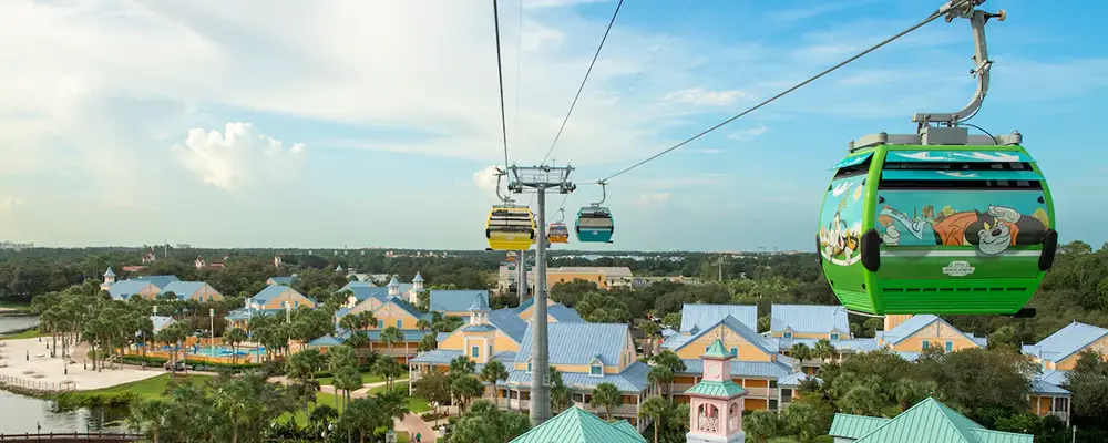 Wdw-skyliner-render-view - Favorite Grampy Travels Colorful Gondolas of an Aerial Cable Car System Travel Above a Walt Disney World Resort Hotel with Blue-roofed Buildings, Palm Trees, and a Pool, Under a Partly Cloudy Sky. - Favorite Grampy Travels - Favorite Grampy Travels 2026