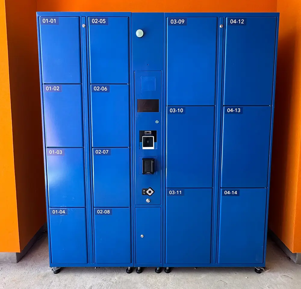 a Blue Locker Unit with Numbered Compartments and a Central Control Panel Stands Against a Bright Orange Wall, Perfect for Families Visiting Universal Kids Resort. the Lockers Are Labeled with White Numbers on Black Stickers. - Favorite Grampy Travels - Favorite Grampy Travels 2026