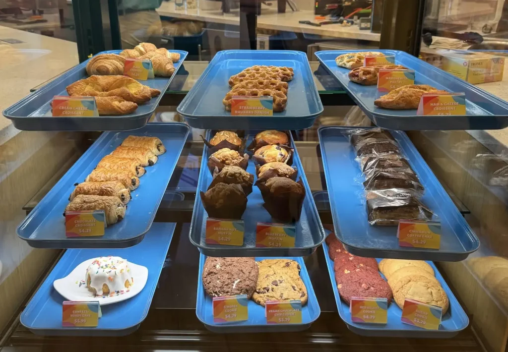 a Bakery Display Case with Blue Trays, Brimming with Croissants, Muffins, Brownies, Cookies, and Cinnamon Rolls—each Treat Labeled with Colorful Price Tags—brings a Taste of Universal Food Fun to Universal Kids Resort. - Favorite Grampy Travels - Favorite Grampy Travels 2026