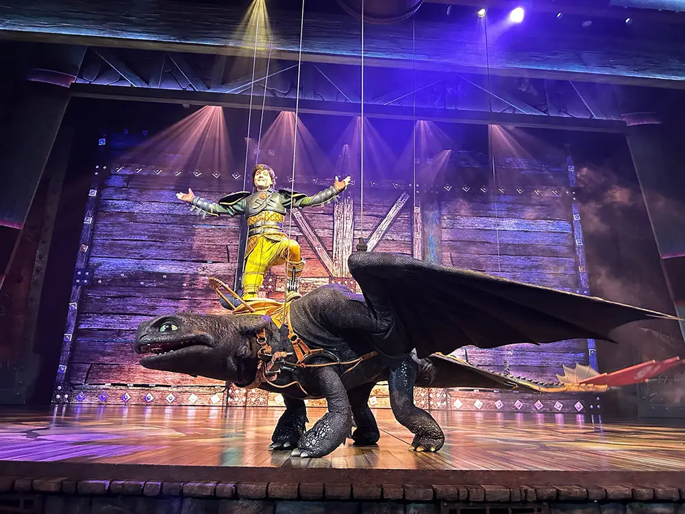 a Performer Dressed As a Viking Stands Triumphantly on Stage with Arms Outstretched, Riding a Large, Lifelike Dragon Puppet Under Dramatic Lighting—an Epic Universe Brought to Life for Those Trip Planning Unforgettable Days Needed for Adventure. - Favorite Grampy Travels - Favorite Grampy Travels 2026