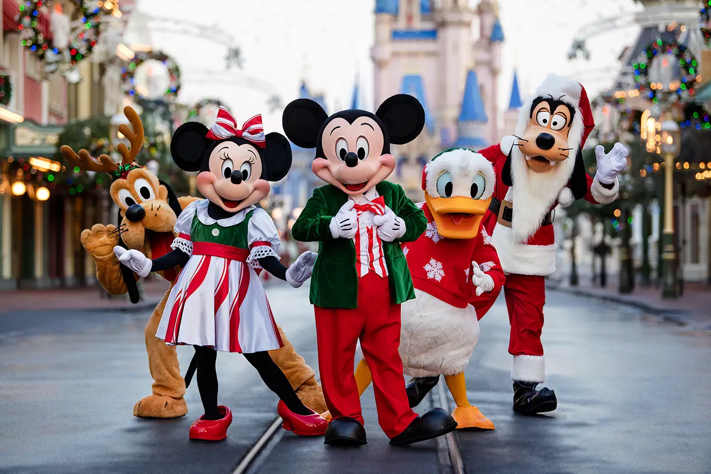 Mickey Mouse, Minnie Mouse, Donald Duck, Goofy, and Pluto Dressed in Festive Christmas Outfits Pose Together in Front of a Castle at a Decorated Magic Kingdom Theme Park. - Favorite Grampy Travels - Favorite Grampy Travels 2026 - Favorite Grampy Travels 2026