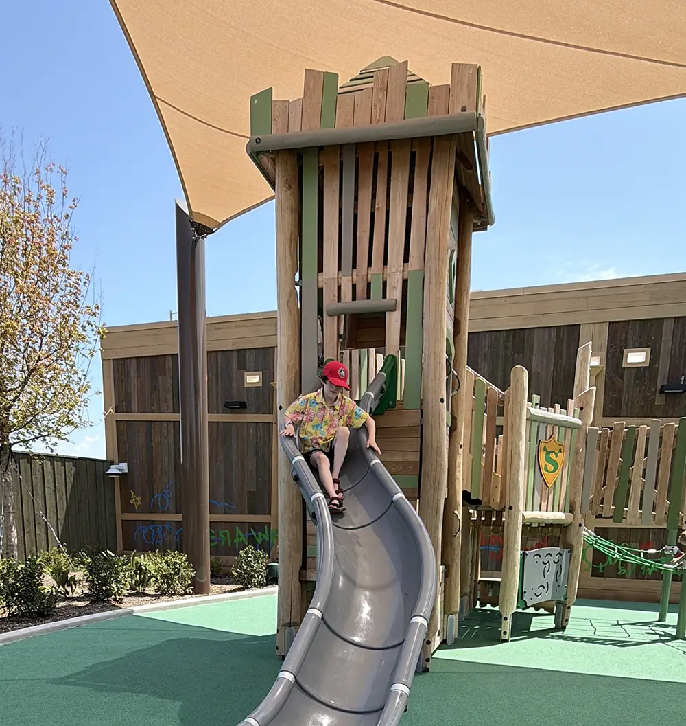 Ukr-shreks-swamp-playground - Favorite Grampy Travels Shrek Themed Playground at Universal Kids Resort with a Wooden Outhouse Tower, Green Shield Crest, Slide and Climbing Structure - Favorite Grampy Travels 2026