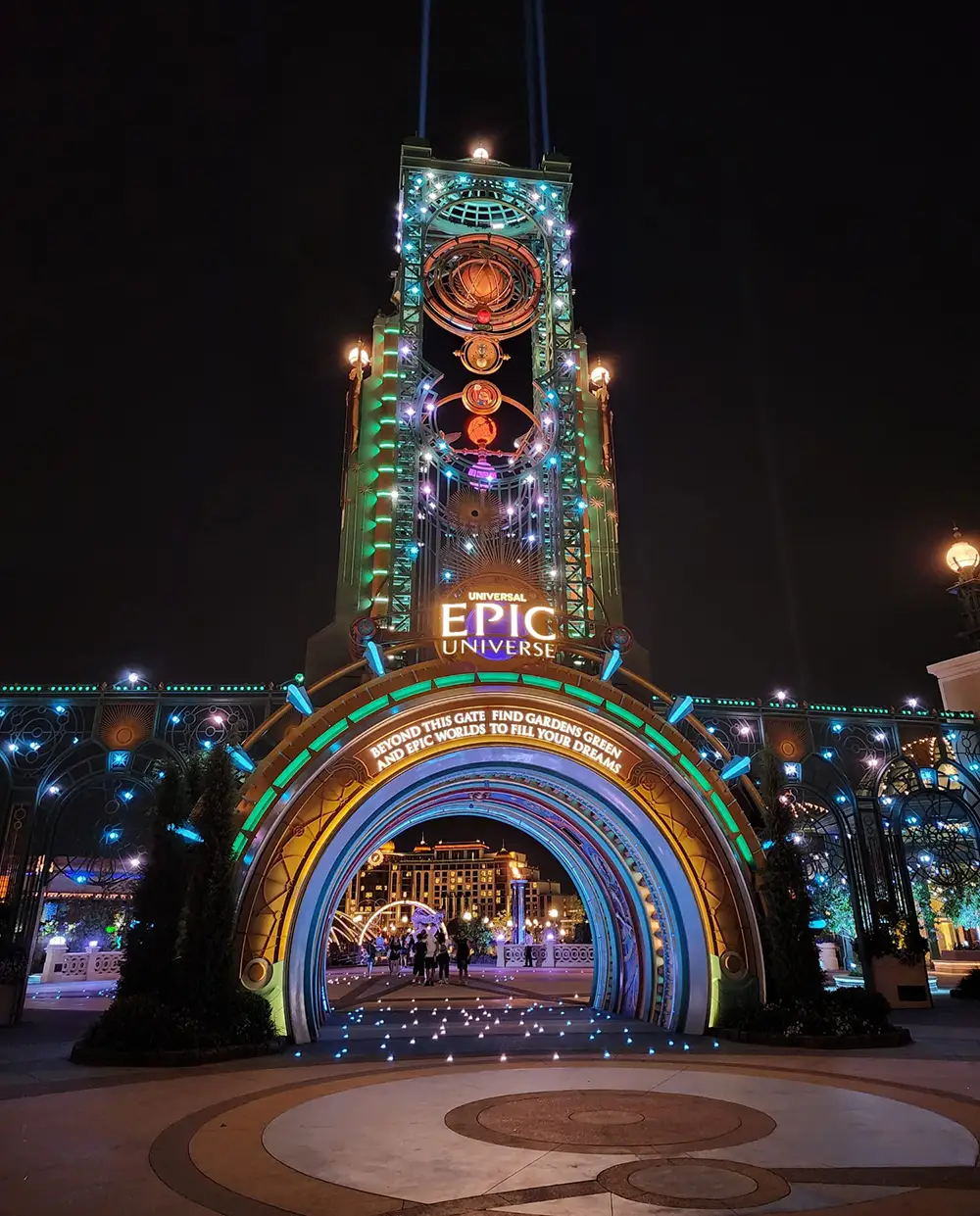 The glowing entrance portal at Universal Epic Universe at night, reached on foot from the park's surface parking lot. - Favorite Grampy Travels