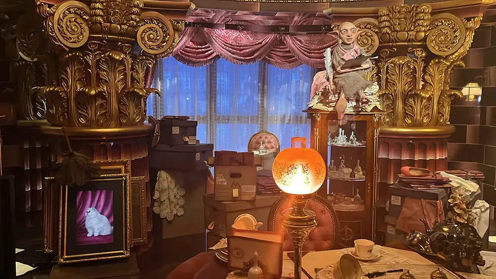 a Lavish, Cluttered Room with Ornate Gold Decor, Stacked Boxes, a Glowing Lamp, Tea Set, Framed Cat Portrait, and a House-elf Figure Sitting Atop a Cabinet Near a Curtained Window Evokes the Whimsical Charm of the Ministry of Magic in the Wizarding World of Harry Potter. - Favorite Grampy Travels - Favorite Grampy Travels 2026