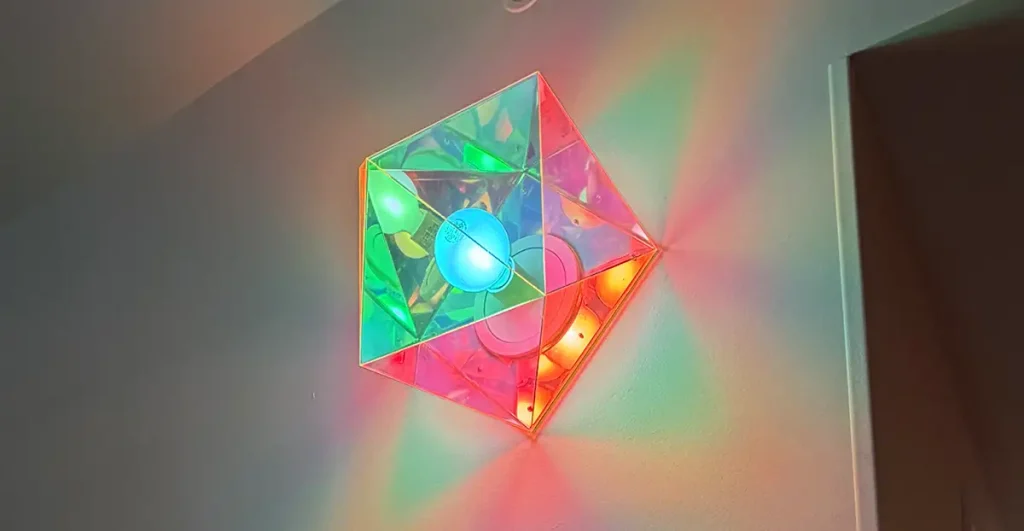 a Geometric, Pyramid-shaped Light Fixture on a Wall Casts Colorful Red, Green, Yellow, and Blue Reflections in a Prismatic Pattern at Universal Kids Resort. - Favorite Grampy Travels - Favorite Grampy Travels 2026