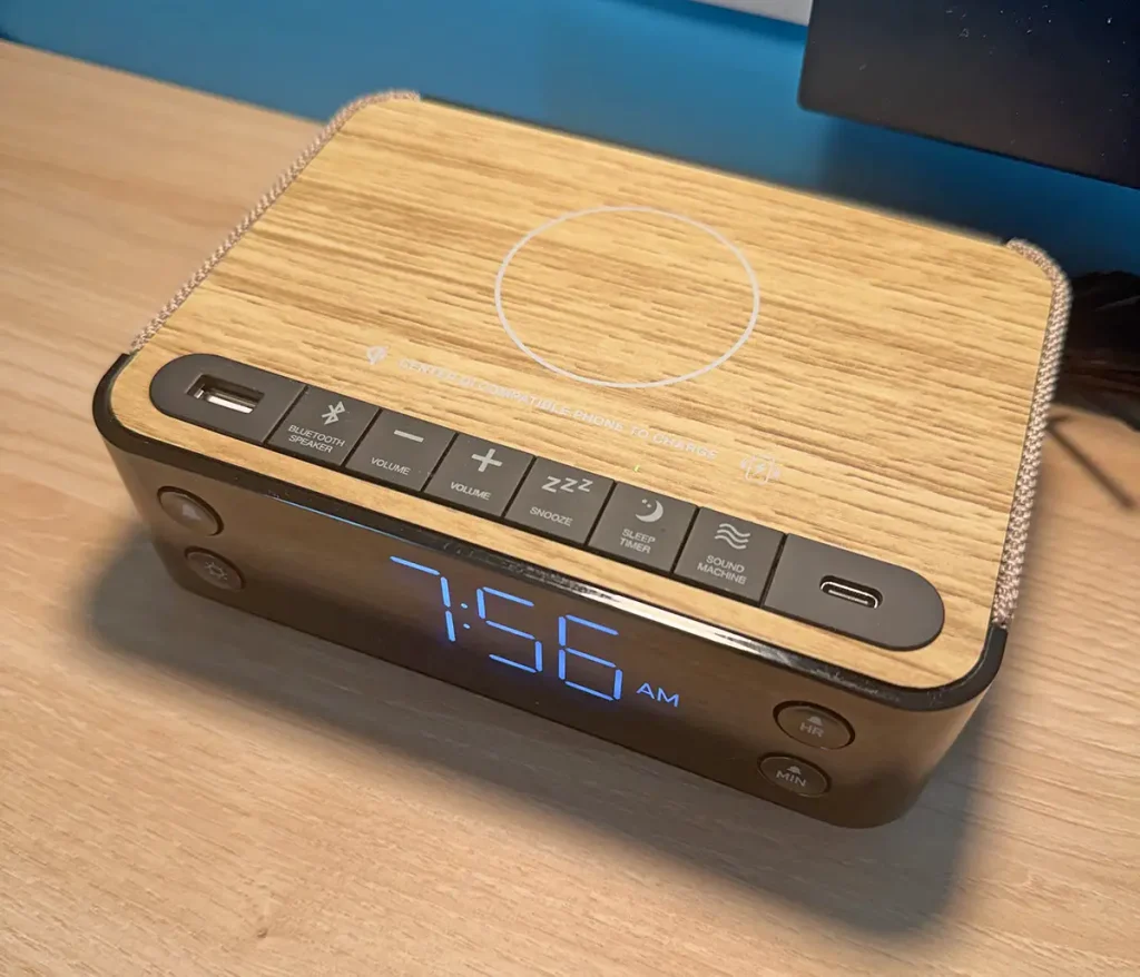 a Digital Alarm Clock with a Wood-patterned Top, Blue Led Display Showing 7:56 Am, and Various Buttons for Volume, Snooze, Bluetooth, and Usb Charging, Placed on a Wooden Surface at Universal Kids Resort Hotel. - Favorite Grampy Travels - Favorite Grampy Travels 2026
