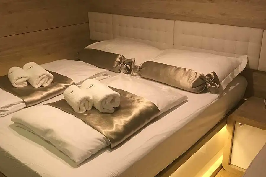 A double cabin aboard the yacht Lastavica with a double bed, warm wood joinery, and a private ensuite bathroom