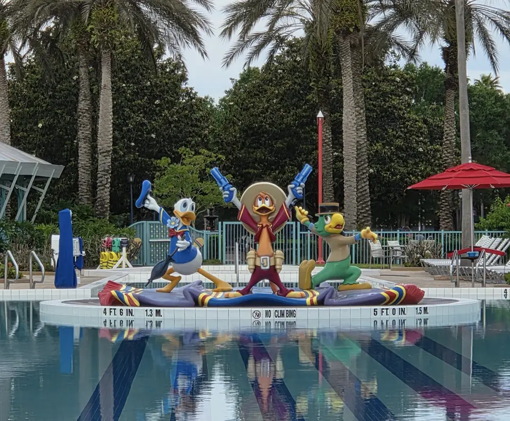 Statues of Three Cartoon Birds in Sombreros and Ponchos, Holding Blue Water Guns, Stand on a Platform by a Pool. Palm Trees and Poolside Chairs Are in the Background. - Favorite Grampy Travels - Favorite Grampy Travels 2026