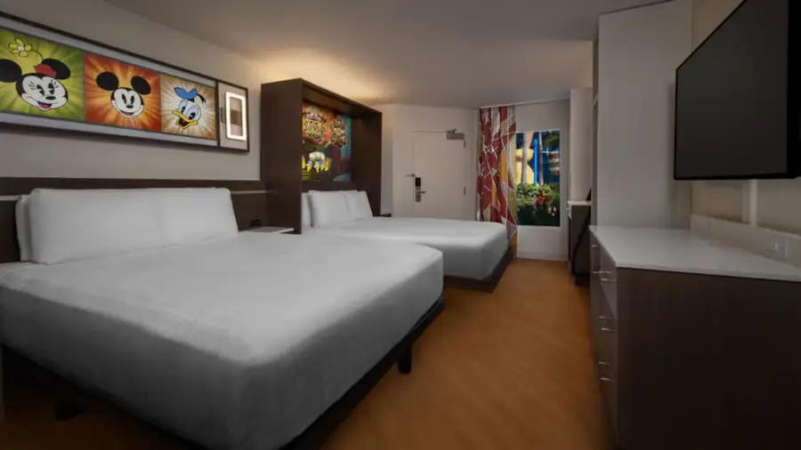 Hotel Room with Two Double Beds, Disney-themed Artwork on the Wall, Flat-screen Tv, Dresser, and Colorful Curtains by the Window. Bright, Modern Decor with Wood Floors and White Bedding. - Favorite Grampy Travels - Favorite Grampy Travels 2026
