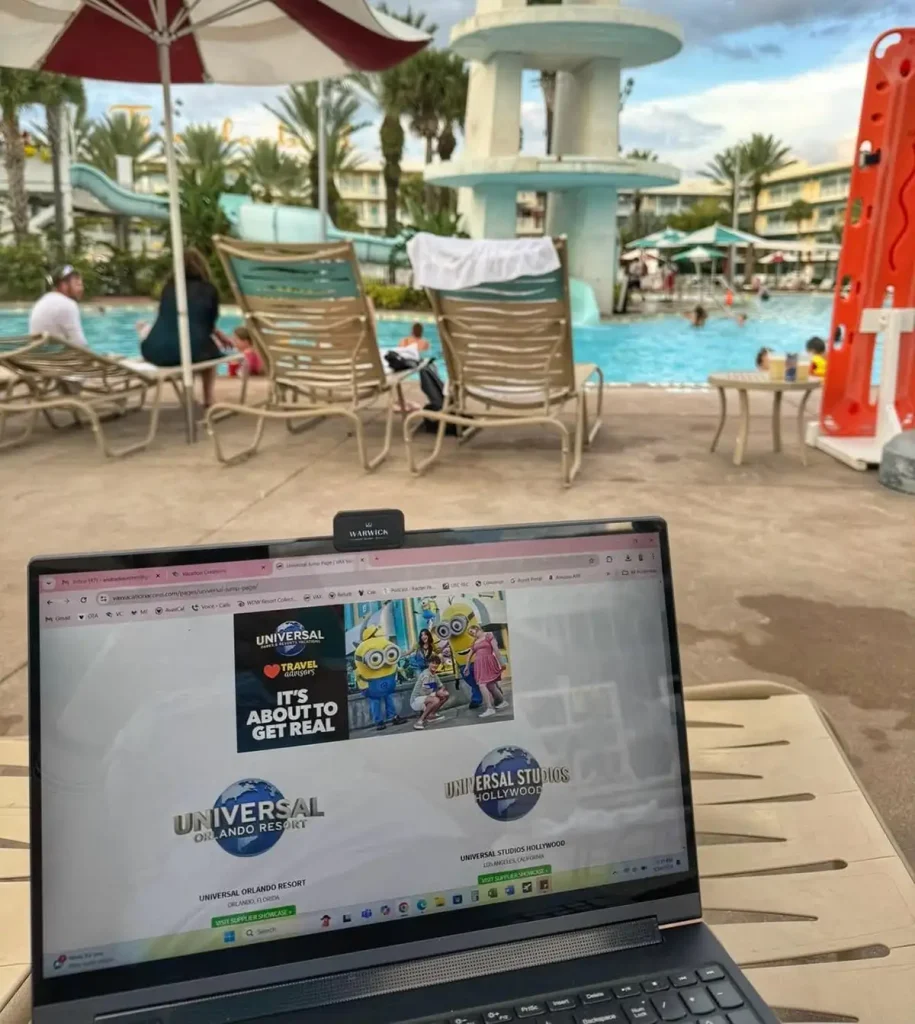 A laptop showing a Universal Orlando Resort webpage sits on a lounge chair beside a pool, with palm trees, people swimming, and a waterslide in the background. - Favorite Grampy Travels