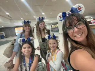 Nicole and the girls in cruise Mickey ears at the airport on the way to their Disney cruise