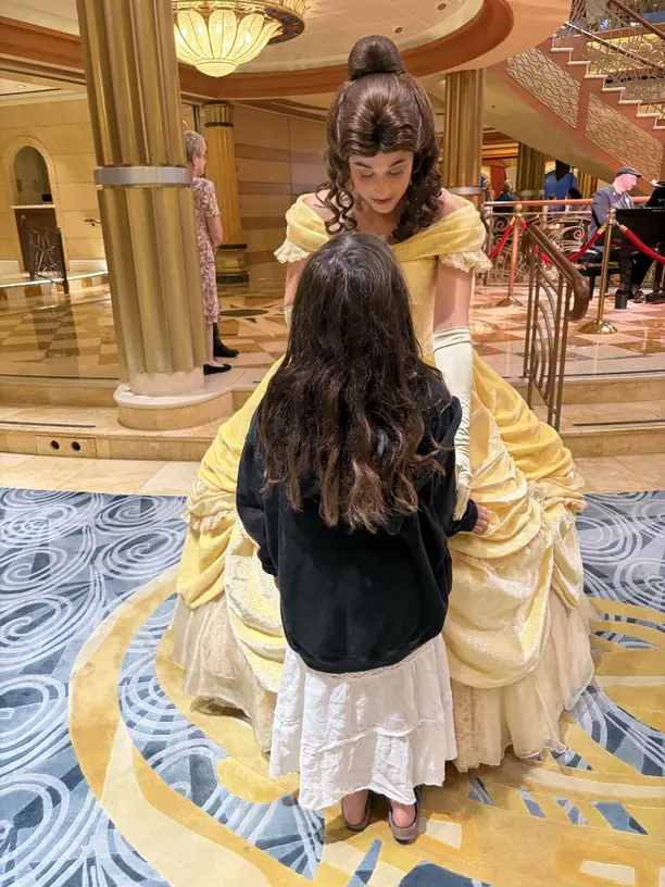 Avilene meeting Belle in the atrium of a Disney cruise ship