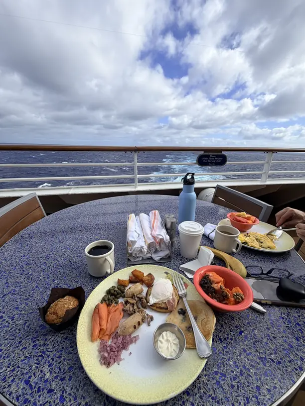 Breakfast outside at a table by the rail with the ocean behind on a Disney cruise