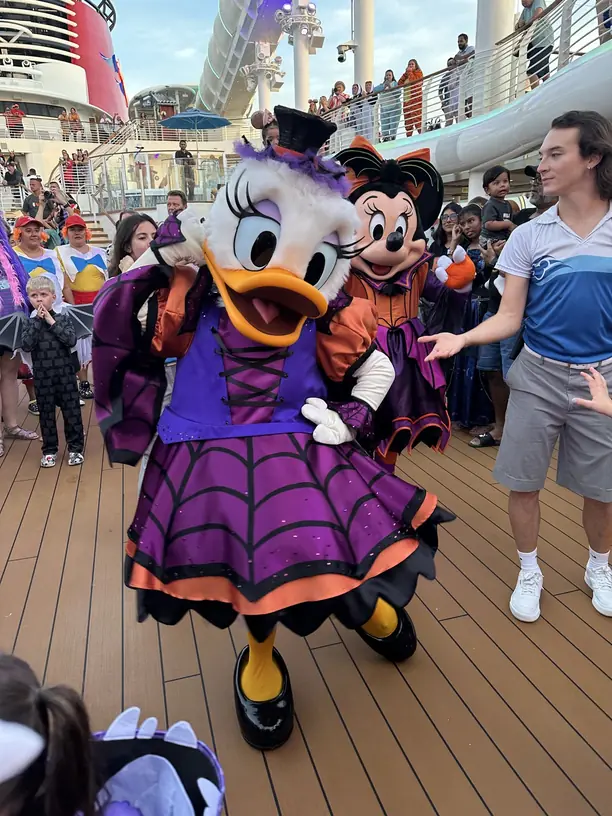 Daisy Duck and Minnie Mouse in Halloween costumes at the deck party on a Halloween on the High Seas Disney cruise
