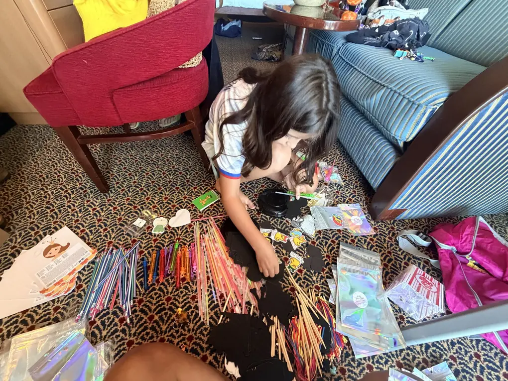 Avilene sorting fish extender gifts on the stateroom floor of a Disney cruise