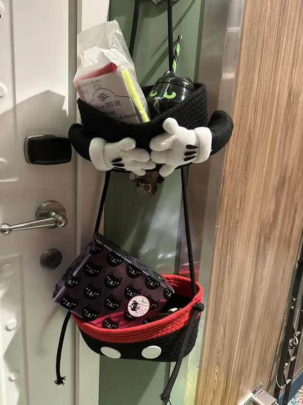 A Mickey Mouse fish extender hanging by a Disney cruise stateroom door filled with Halloween gifts