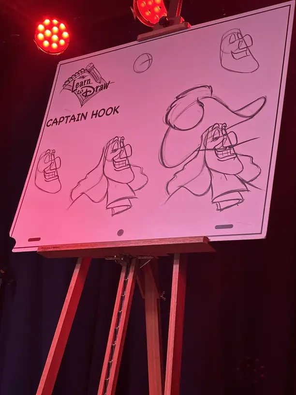 Captain Hook sketches on the easel at a Disney cruise Learn to Draw class