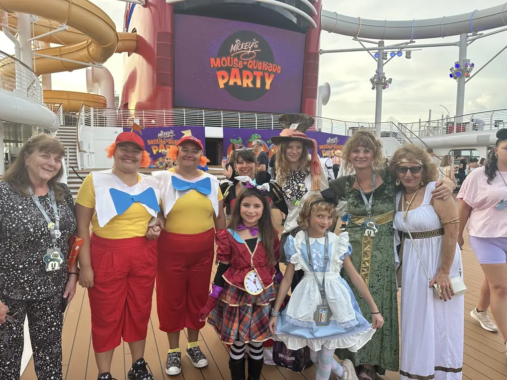 Family and friends in Alice in Wonderland costumes at Mickey's Mouse-querade Party on a Disney cruise
