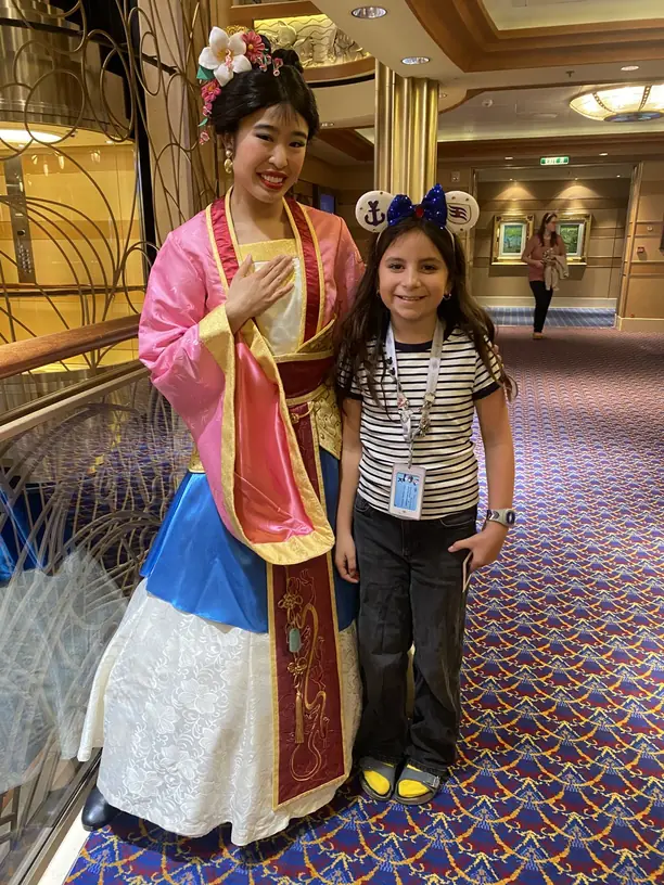 Avilene in Mickey ears meeting Mulan on a Disney cruise