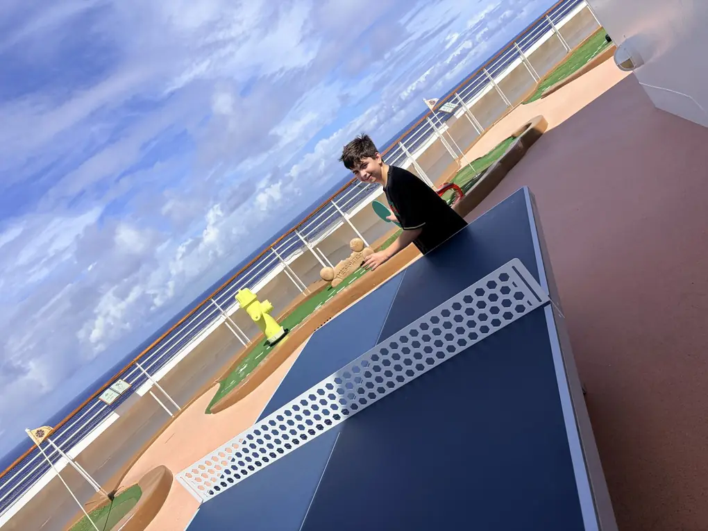 Jake playing ping pong on the sports deck of a Disney cruise