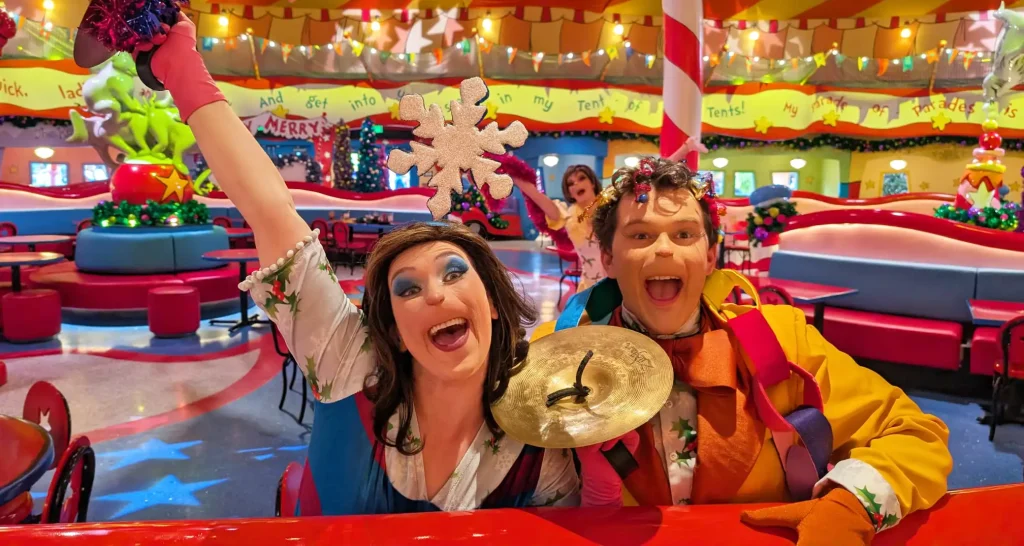 Two Who performers cheer with a cymbal and a snowflake inside Circus McGurkus Cafe during the Grinch breakfast at Universal Orlando