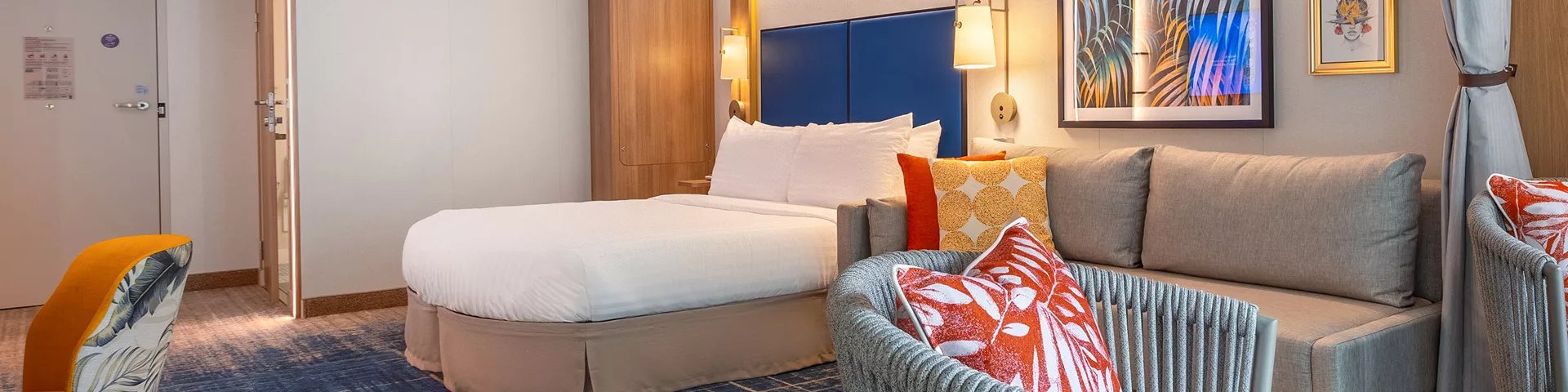 Bed and sofa in an accessible Spacious Infinite Central Park View Balcony stateroom on Icon of the Seas