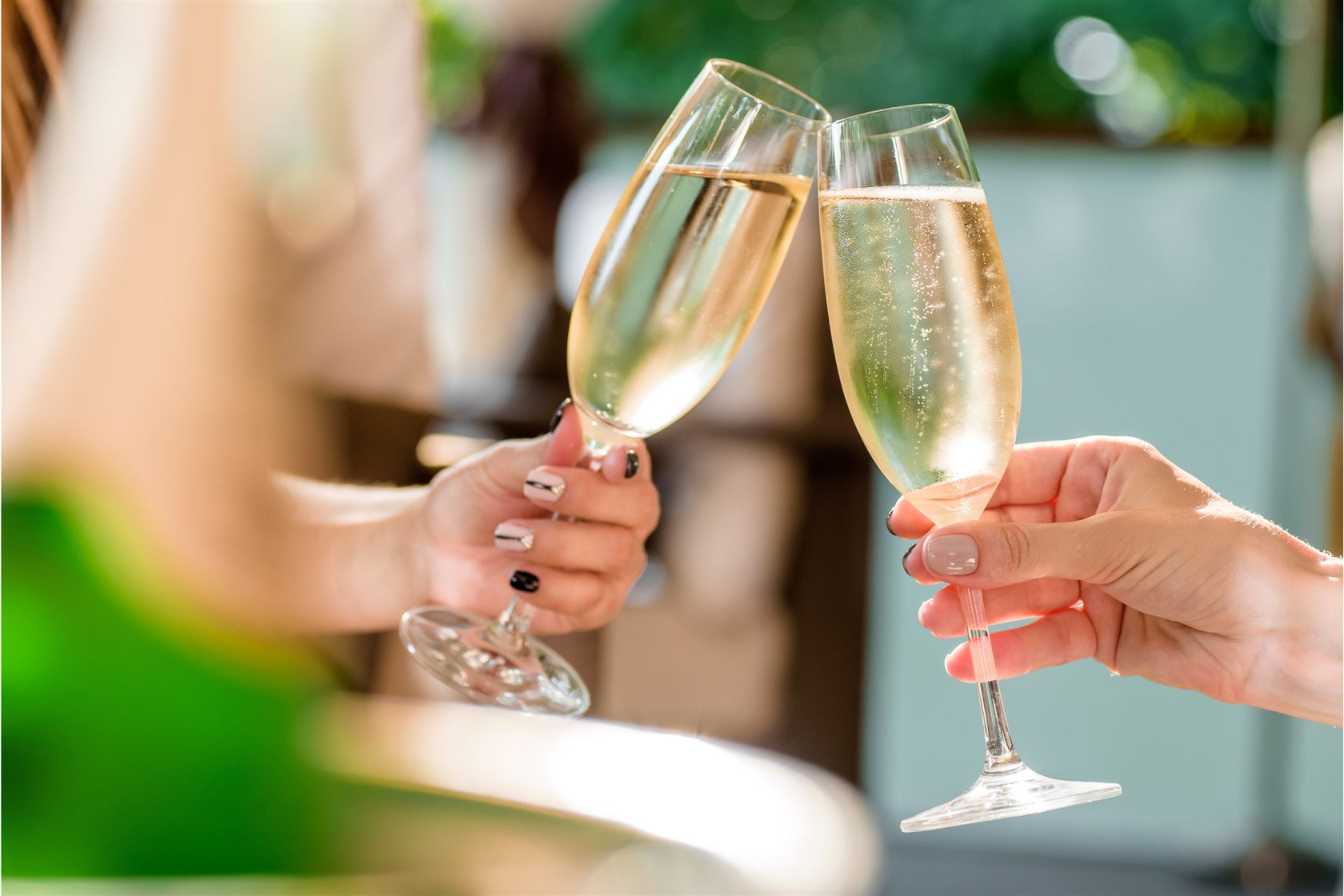 Two champagne flutes raised in a toast at Bubbles in Central Park on Icon of the Seas