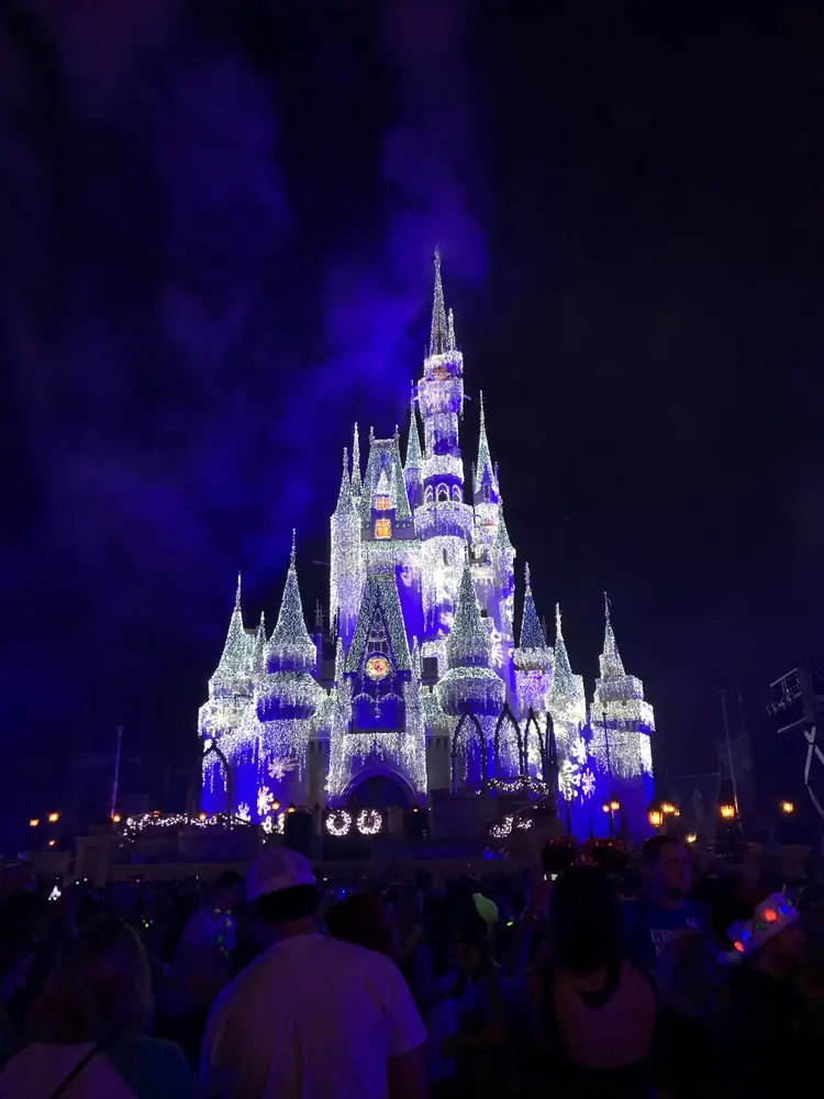 Cinderella Castle lit blue at night at Magic Kingdom
