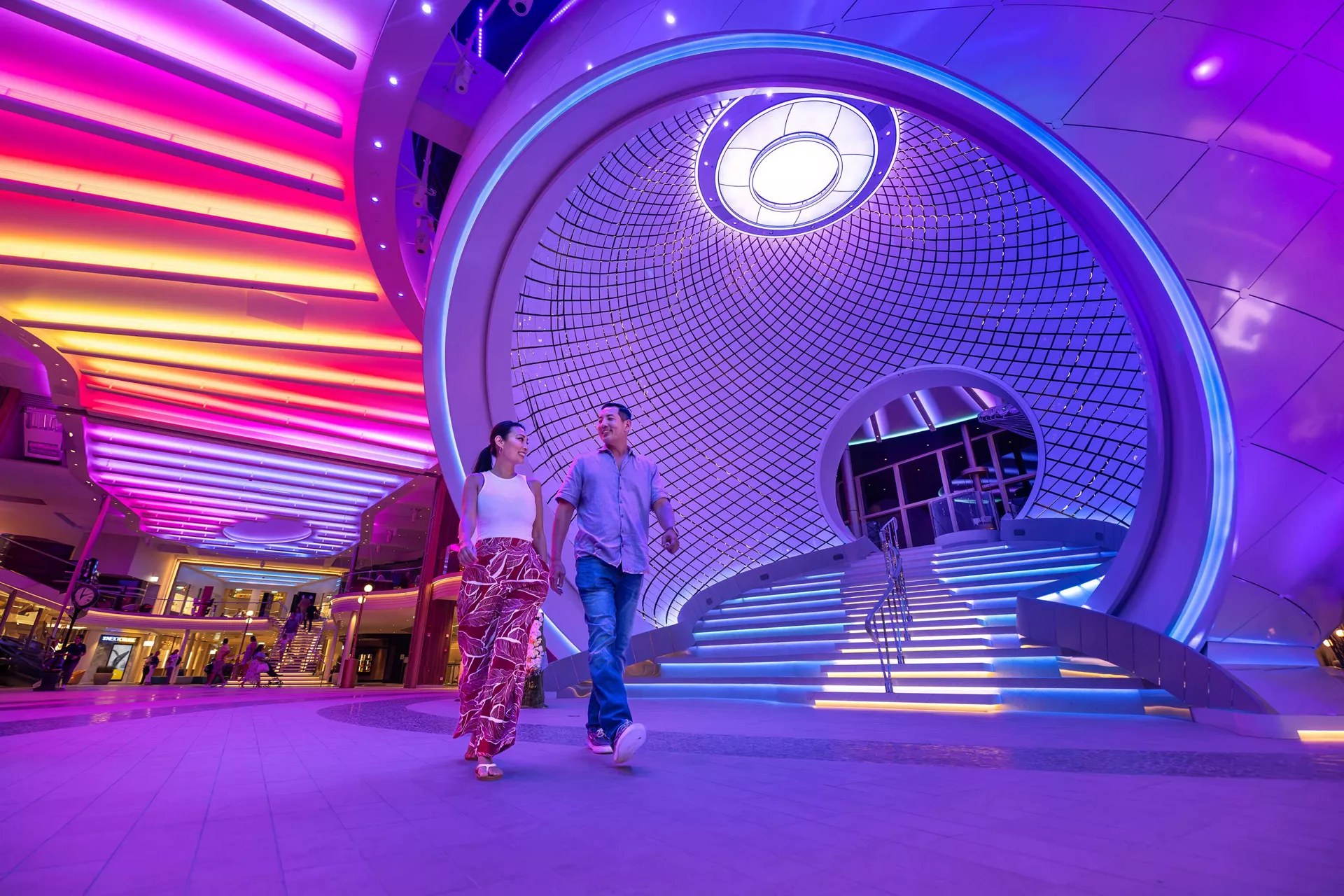 Couple walking past The Pearl on the Royal Promenade of Icon of the Seas