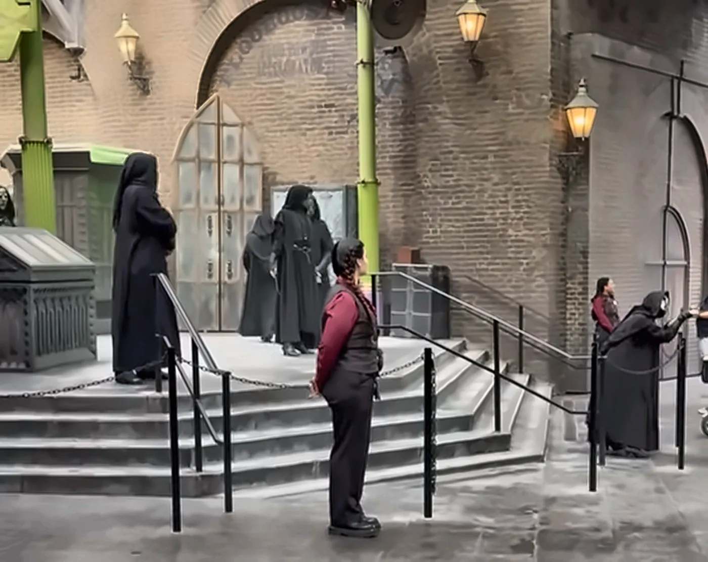 Death Eaters Performing on Gringotts Bank Steps in Diagon Alley at Halloween Horror Nights - Favorite Grampy Travels - Favorite Grampy Travels Death Eaters in black robes performing on the steps of Gringotts Bank in Diagon Alley with a Team Member standing nearby.