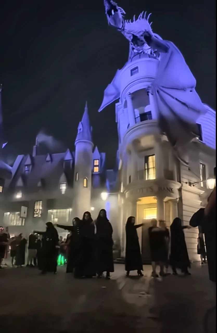 Death Eaters in Diagon Alley Under Gringotts Dragon at Halloween Horror Nights - Favorite Grampy Travels - Favorite Grampy Travels Death Eaters in black robes gathered under the Gringotts dragon in Diagon Alley at night during Halloween Horror Nights.