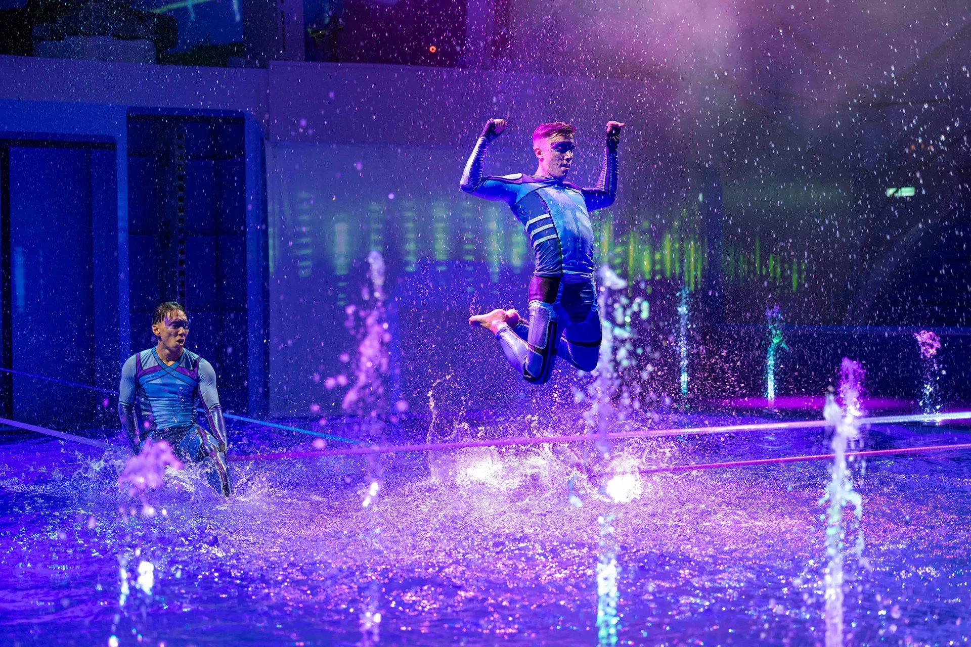 Performers leaping through water jets during an AquaTheater show on Icon of the Seas