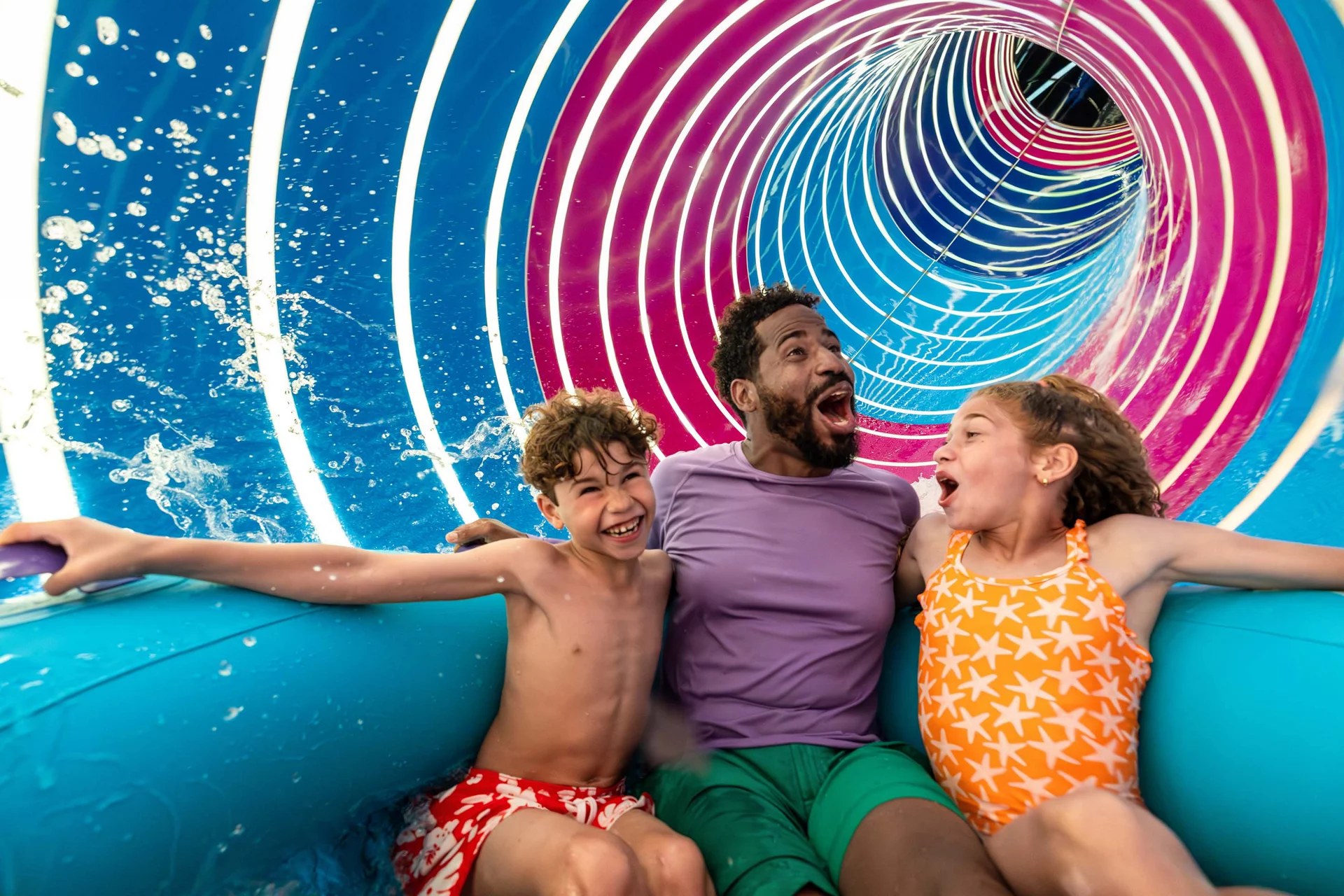 Family riding the Hurricane Hunter raft slide at Category 6 on Icon of the Seas