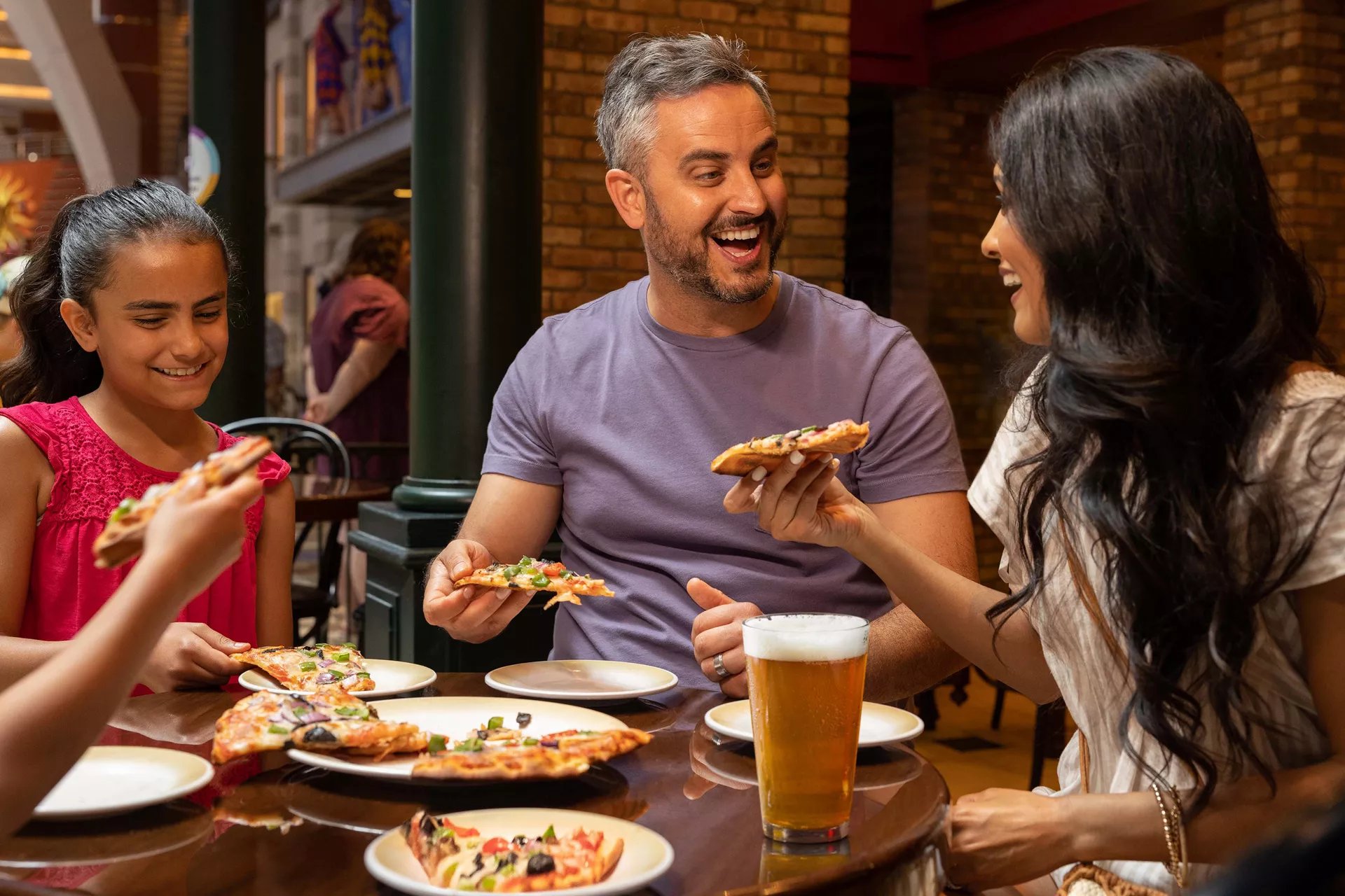 Family sharing pizza at Sorrento's on the Royal Promenade of Icon of the Seas