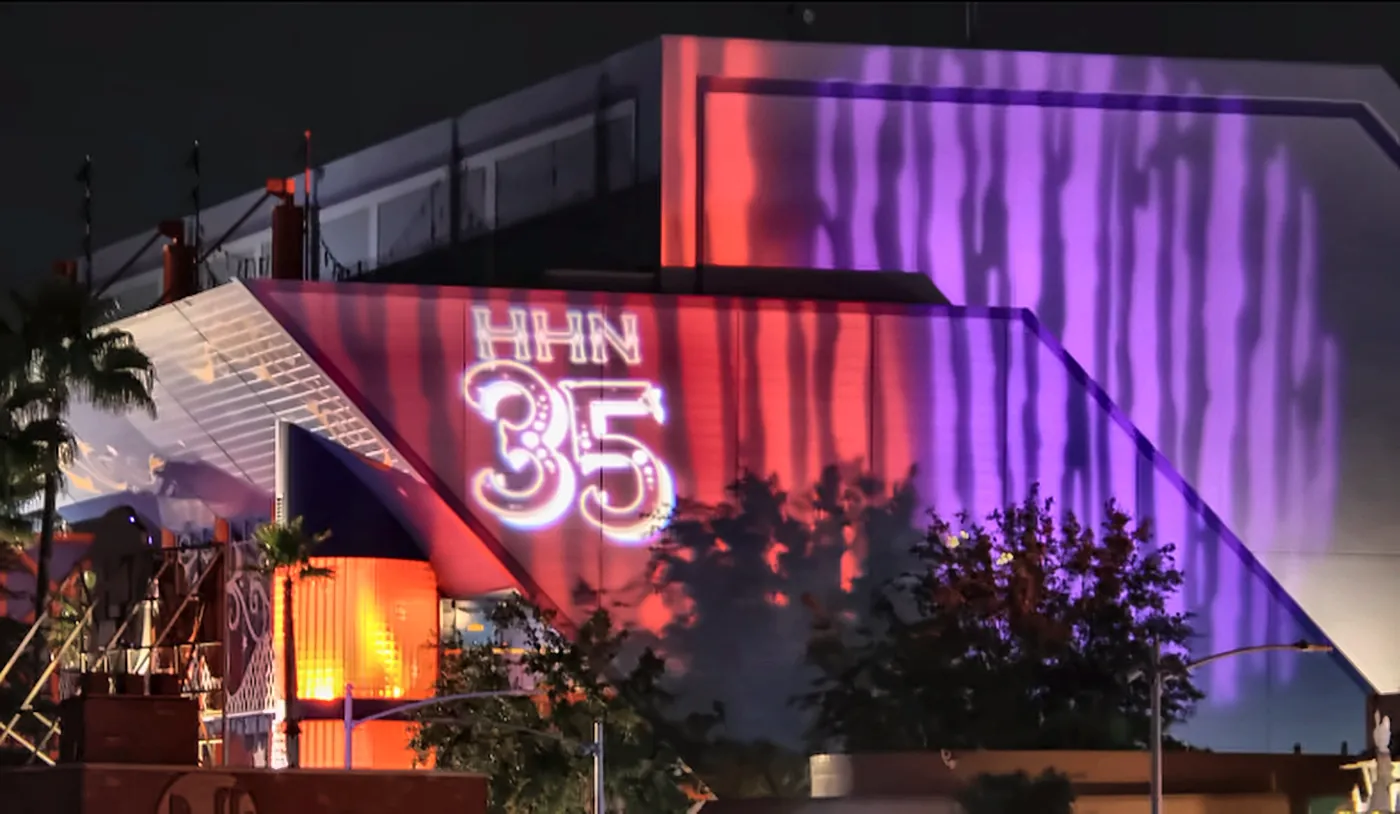 Halloween Horror Nights 35 Logo Projected on Universal Studios Florida Building - Favorite Grampy Travels - Favorite Grampy Travels The Halloween Horror Nights 35 logo projected in red and purple on a Universal Studios Florida building at night.