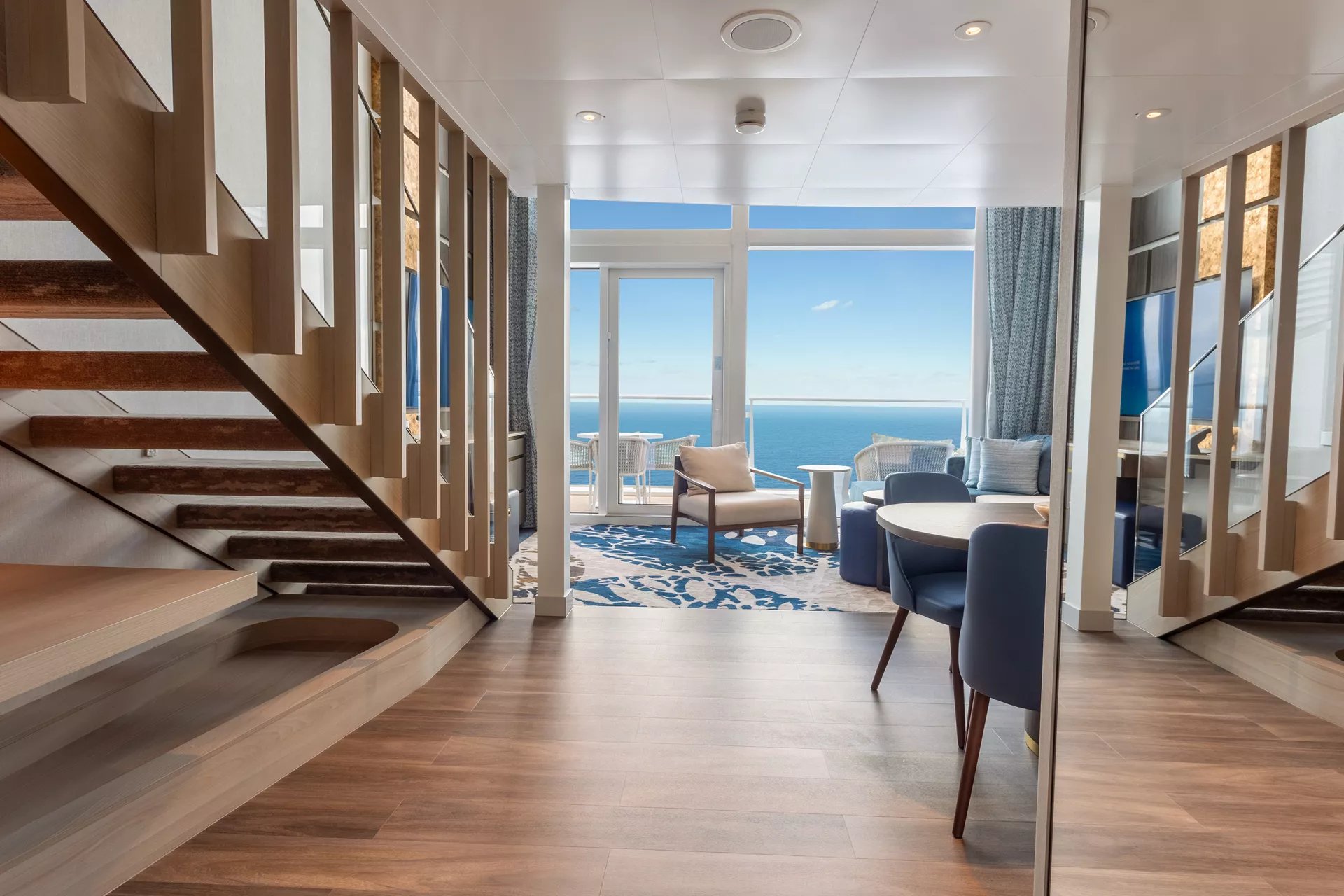 Dining room and staircase of an Icon Loft Suite on Icon of the Seas Deck 17