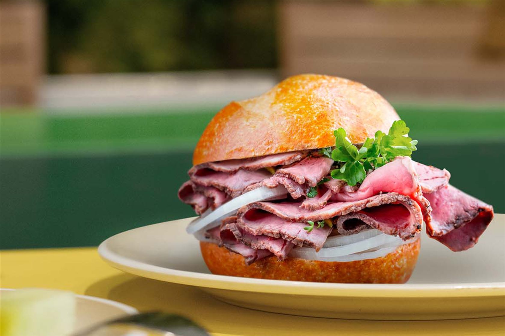 Kummelweck roast beef sandwich on a plate at Park Cafe on Icon of the Seas