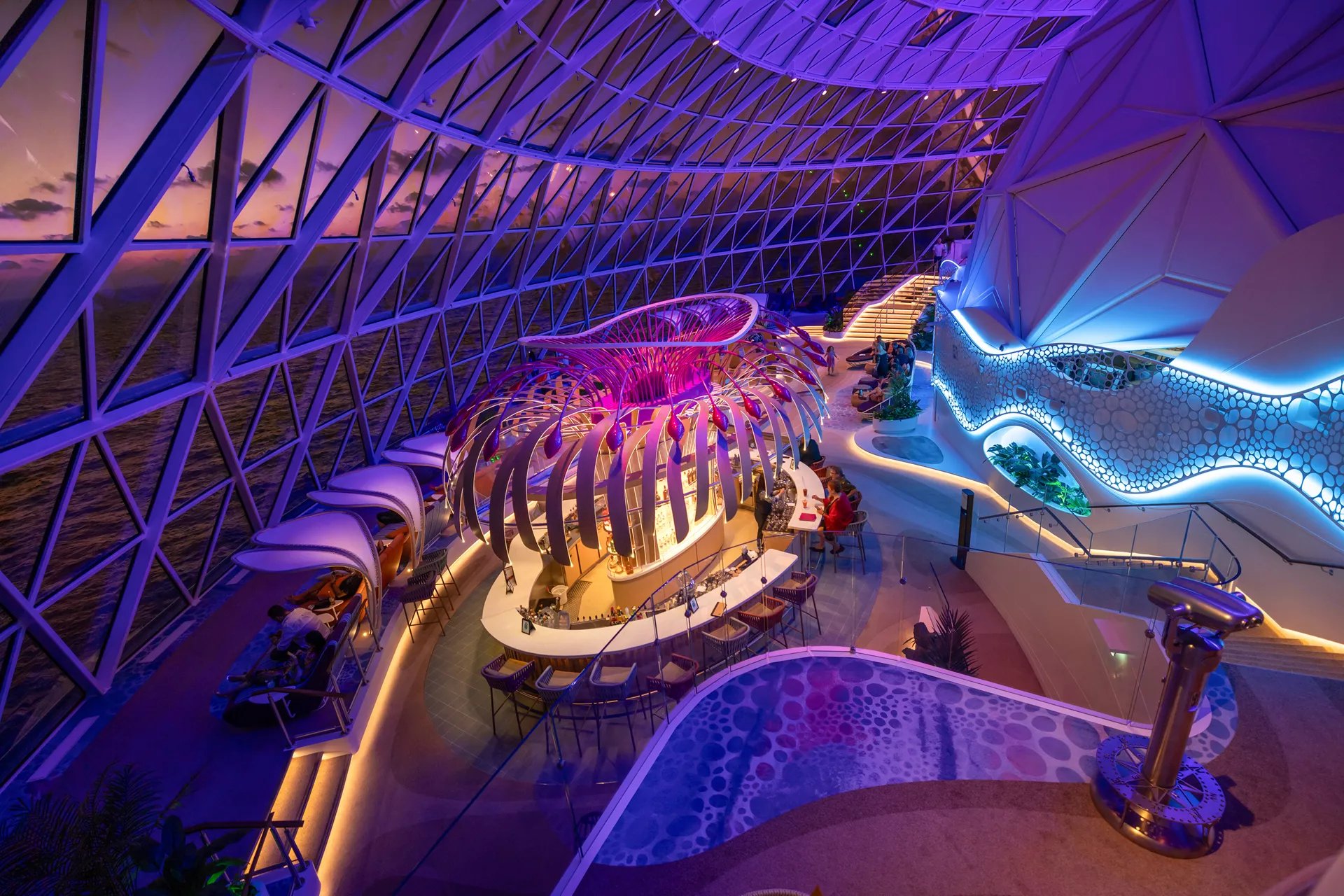 The Overlook lounge and bar at night under the glass AquaDome on Icon of the Seas